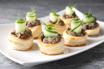 Delicious puff pastry with mushrooms, cucumber and dill on grey table, closeup