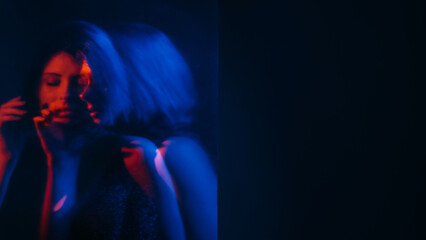 Mental pain. Defocused silhouette. Silent woman hearing voices neon red blue hands listening inner headache double exposure empty space out of focus.