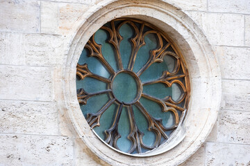 Round Gothic window with wooden frame in stone wall