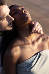 A couple in love walks along the embankment by the sea at sunset
