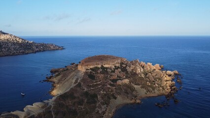 Qarraba Bay flat rock cape Malta, Aerial establishing shot in the morning sunlight. High quality photo