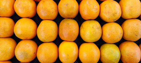 piles of fresh, fragrant oranges (citrus) in the supermarket