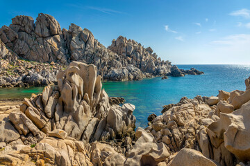 View of a scenic cove (Cala di l'Ea) between rocks on the mediterranean coast in Capo Testa,...
