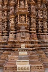 Sculptures and intricate designs carved on the wall of Kandariya Mahadeva Temple in the Khajuraho temple complex, In