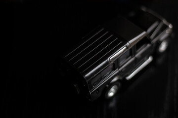 Black SUV. Toy car model. SUV from the collection of cars. Black background.
