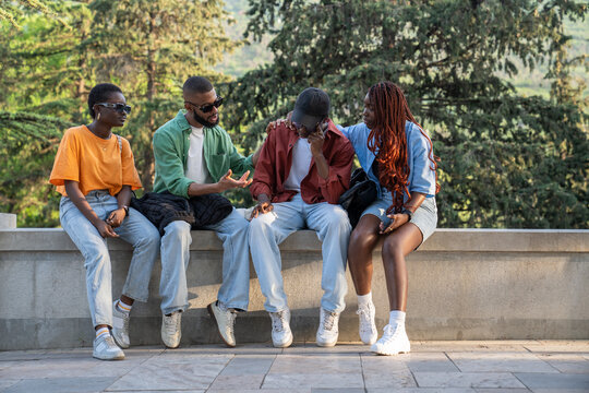 Worried african american students support sad frustrated friend guy in trouble trying to find solutions to problems outdoor. Frustrated sad black young man talking with friends after difficult exam. 