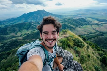 Naklejka premium Selfie of a young man at the top of a cliff with panoramic mountain view