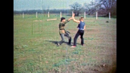 Professional training of Asian martial arts in outdoor. Male person demonstrating karate hand-to-hand combat skills. Sport sparring attack. Fighting workout. Vintage color film. Retro archive. 1980s - Powered by Adobe