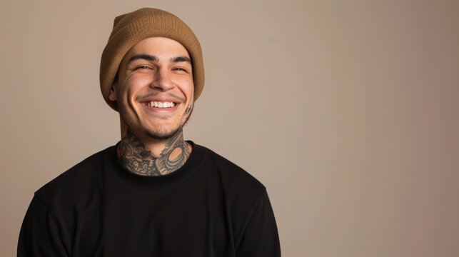 A smiling man with tattoos on his neck, wearing a black beanie, showcasing an alternative and modern style.
