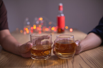 A group of businessmen held brandy glasses together to cheers glasses of brandy after concluding...