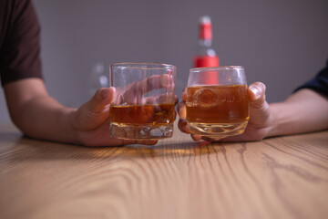 A group of businessmen held brandy glasses together to cheers glasses of brandy after concluding negotiations on business ventures and reaching a satisfactory agreement for joint business profits.