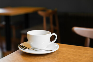White porcelain cup of black coffee on a saucer in a cafe