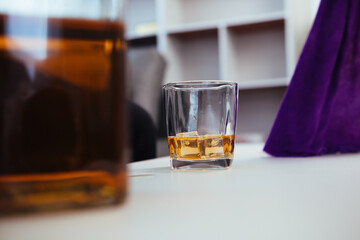 brandy glass that is kept on table in office is a glass of brandy that business people often drink after working hours to let the alcohol help them relax. Concept of relaxing with alcoholic beverages
