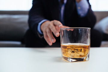 brandy glass that is kept on table in office is a glass of brandy that business people often drink after working hours to let the alcohol help them relax. Concept of relaxing with alcoholic beverages