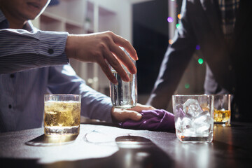 Businessmen and investors drink alcohol together in office after discussing their joint venture...