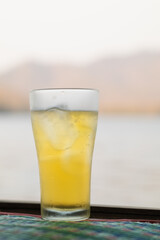 Beer, served in glasses, is a popular alcoholic drink around the world and is often used as a celebratory drink during festivals. Beer was served with ice in beer glasses because of the hot weather.