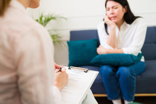 Attentive female psychologist listens to a woman sharing her problems during a mental health therapy session
