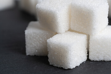 Refined sugar cubes on slate. Food item.