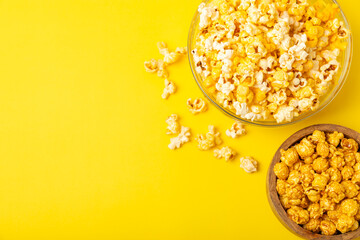 Delicious popcorn in a bowl on a yellow background. Cinema and entertainment concept. Movie night with popcorn.Cheese and caramel popcorn. Delicious appetizer, snack. Place for text. Copy space.Banner