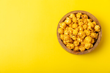 Delicious popcorn in a bowl on a yellow background. Cinema and entertainment concept. Movie night with popcorn.Cheese and caramel popcorn. Delicious appetizer, snack. Place for text. Copy space.Banner