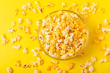 Delicious popcorn in a bowl on a yellow background. Cinema and entertainment concept. Movie night with popcorn.Cheese and caramel popcorn. Delicious appetizer, snack. Place for text. Copy space.Banner