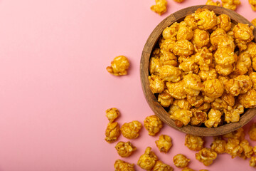 Delicious popcorn in a bowl on a pink background. Cinema and entertainment concept. Movie night with popcorn. Cheese and caramel popcorn. Delicious appetizer, snack. Place for text. Copy space.Banner