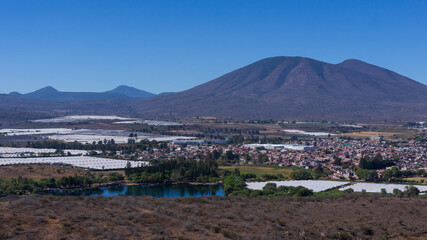 Panoramic over the upper part of Jacona, Michoacan, you can see the La Luz dam and its enormous pine trees, a bit of the industry around it and the growing urban area.