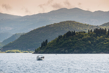 A scenic boat cruise on Lake Skadar in Montenegro offers panoramic views of lush forests, towering mountains, and tranquil waters, perfect for birdwatching enthusiasts.