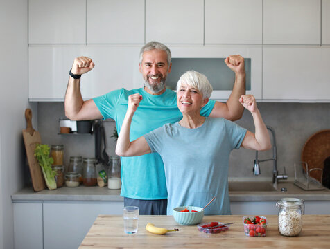 kitchen food woman healthy couple senior mature active fitness diet homeadult sport fit health breakfast nutrition muscle bicep strong strength flexing
