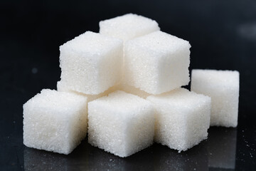 Sugar cubes on a black background. Closeup photo.