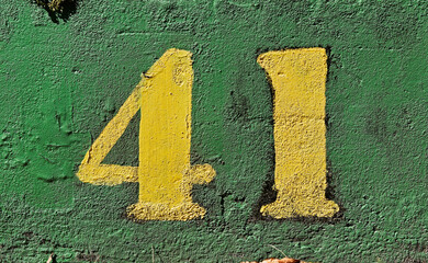 Number 41 painted in yellow on a green wall