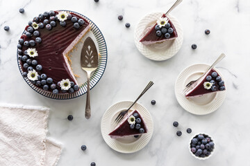 Slices of blueberry cheesecake with the remaining cake to the side.