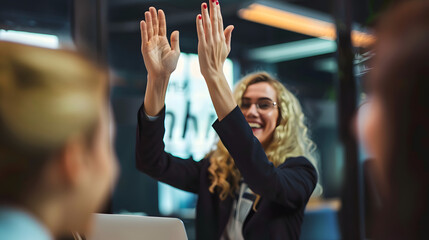 Businesswoman giving a high five to the colleague in meeting room celebrating success. Happy...