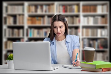 Cheerful young university student girl research in library