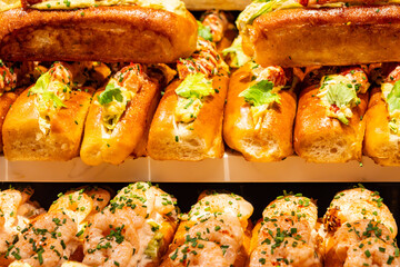 Fresh baked brioche buns filled with eggs, truffles, crab meat and shrimps ready to eat in food hall, London, Covent Garden market