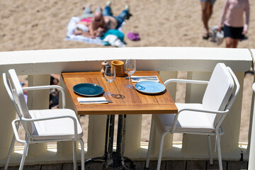 Before lunch time, empty stylish beach cafe with served tables waiting for guests in sunny...