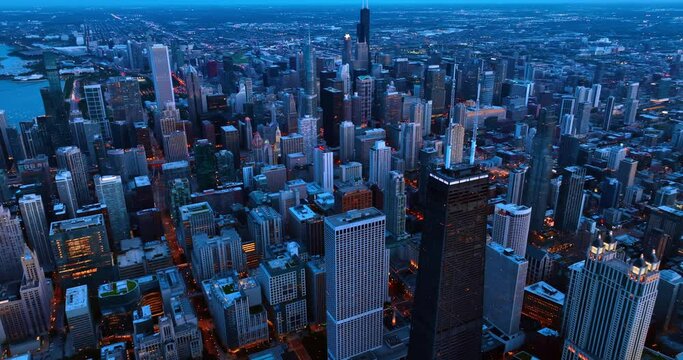 Flight over the highest buildings in the downtown of Chicago, Illinois. Vast panorama of the city at dusk.