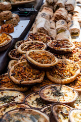 Tasty vegetarian streetfood for lunch in London, various quiche savoury tart swith spinach, tomatoes, mushrooms, cheddar cheese