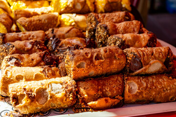Homemade sweet pastry cannolo siciiano filled with almond, pistachio, lemon, vanilla, chocolate cream