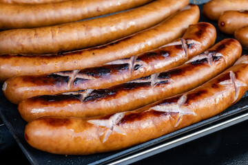 German street food on Portobello road Saturday food market, London, Uk, many BBQ grilled sausages ready to eat in outdoor café