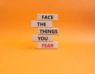 Face the things you fear symbol. Wooden blocks with words Face the things you fear. Beautiful orange background. Business and Face the things you fear concept. Copy space.