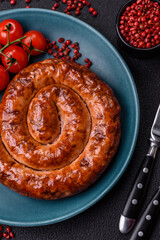 Delicious homemade sausage in the form of a spiral baked on the grill with salt, spices