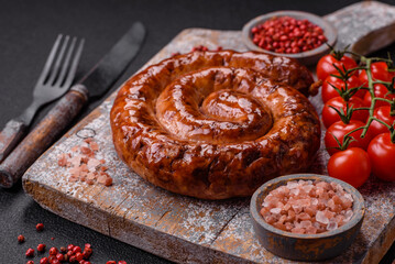 Delicious homemade sausage in the form of a spiral baked on the grill with salt, spices