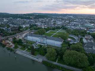 Electoral Palace in Koblenz, Germany, along the Rhine River at sunset with an aerial bird's eye view of iconic buildings of the city.