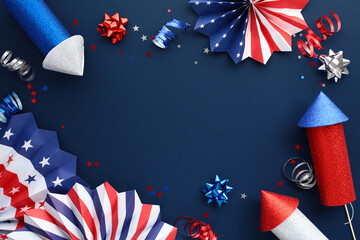 Frame of American flag colors paper fans, firework rockets, confetti on dark blue background. US...