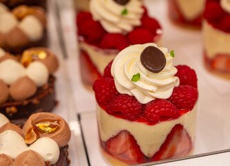 Various sweet cakes meringue, red fruits and berries framboise tartlets with cream