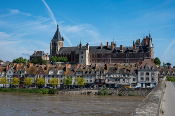Obraz premium View.on old part of town of Gien on the Loire river, in Loiret department, France, houses with tiled roofs and chimneys, castle and bridge