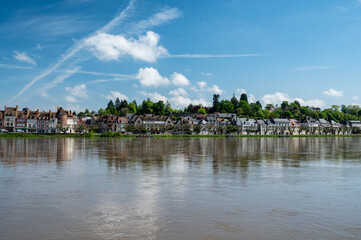 View.on old part of town of Gien on the Loire river, in Loiret department, France, houses with tiled roofs and chimneys, castle and bridge