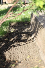 Laying an anti-weed mat in the garden together with paving stones and decorative pebbles.