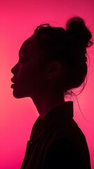Silhouette of a Woman With Hair in a Bun Against a Pink Background. Generative AI